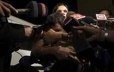 A family is mobbed by reporters after their arrival from Libya