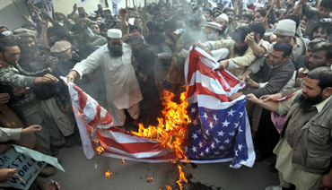 Protestors in Pakistan burn a US flag during a rally against Davis near the US consulate