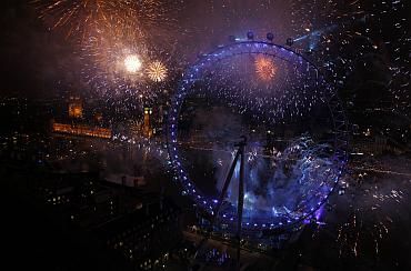 Fireworks explode beside the London Eye and The Houses of Parliament on the River Thames during New Year celebrations in London