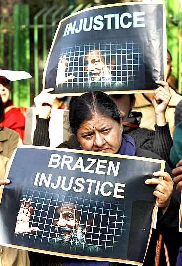 Protesters hold placards during a protest demanding the release of Dr Binayak Sen