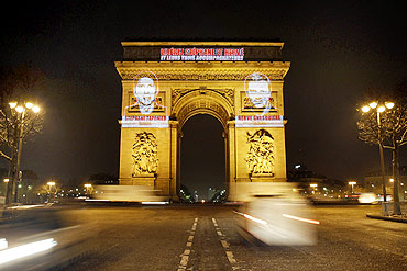 Images of Herve Ghesquiere and Stephane Taponierare projected on the Arc de Triomphe in Paris