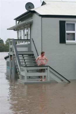Owner Brett Jensen looks on as he stands next to his restaurant affected by floods in Bundaberg, Queensland