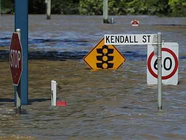 Street signs submerged in flood waters are seen in Kendall Street in Bundaberg, Queensland