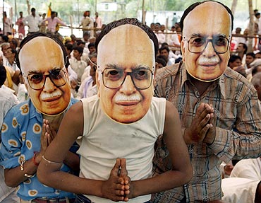 BJP supporters wear masks of senior leader Lal Krishna Advani during an election campaign rally at Biaora in Madhya Pradesh