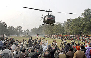 Supporters wave at a helicopter carrying Taseer's body