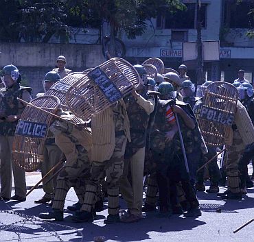 Policemen take cover as pro-Telangana activists throw stones