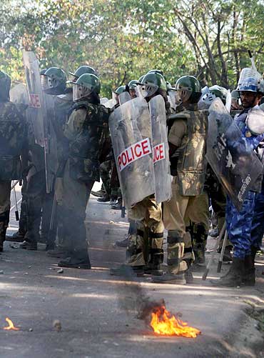 Policemen stand guard as violence erupts in Hyderabad over the Telangana issue
