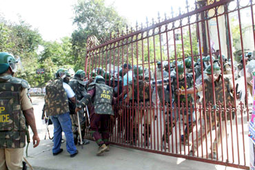 Security forces try to close the main entrance gate of the Osmania varsity