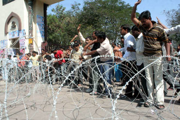 Pro-Telangana students try to break through a barbed wire at the university gate on
