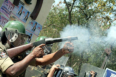 A policeman lobs a tear gas shell near Osmania campus on Friday
