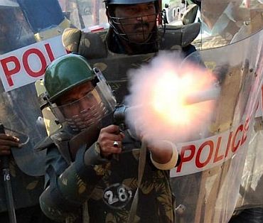 Policemen fire a teargas shell to disperse protestors