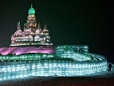 A tourist visits an ice sculpture at a park in Harbin