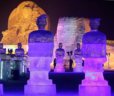 After nightfall, people visit ice sculptures at a park in Harbin