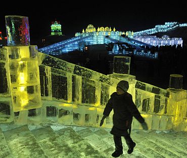 A visitor climbs on icy stairs on an ice sculpture