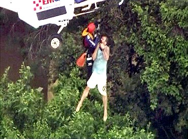 A man is lifted up to a helicopter in the flooded town of Toowoomba, west of Brisbane, in this still image taken from video