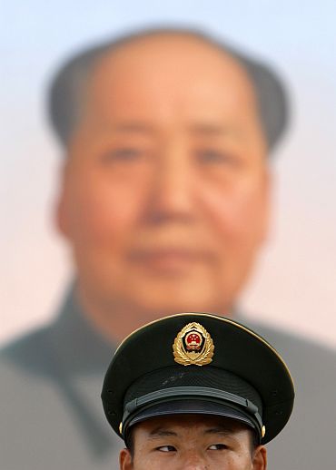 A guard stands beneath the portrait of the late China's Chairman Mao Zedong in Tiananmen Square in Beijing
