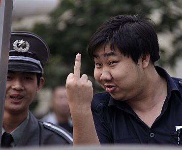 A security personnel gestures at the entrance of a residential compound where Liu Xia, the wife of Chinese dissident Liu Xiaobo, lives in Beijing