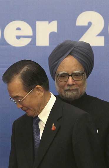 File photo shows China's Premier Wen Jiabao walking past India's Prime Minister Manmohan Singh ahead of a photo opportunity as part of the 5th East Asia Summit in Hanoi