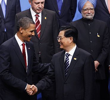 File photo shows US President Barack Obama shaking hands with China's President Hu Jintao as India's Prime Minister Manmohan Singh look on at rear, at the G20 Summit in Pittsburgh