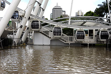 Flood waters are seen in front of the Wheel of Brisbane ferris wheel