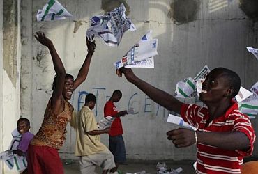 Haitians throw ballots into the air after frustrated voters destroy electoral material during a protest in a voting centre in Port-au-Prince