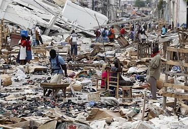 Residents walk in a destroyed area in Haiti