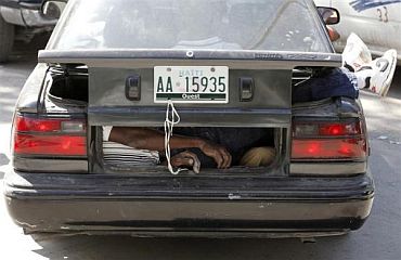A dead victim is seen inside the boot of a car after the earthquake in Port-au-Prince