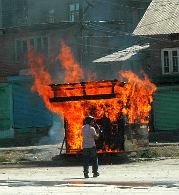A protestor sets a vehicle on fire in Srinagar