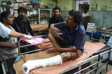 A devotee who was injured after the stampede rests inside a hospital at Kottayam in Kerala