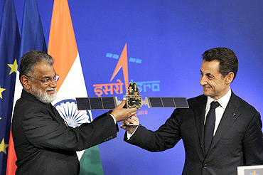 French President Nicolas Sarkozy receives a model of a satellite from ISRO Chairman Dr Radhakrishnan in Bengaluru