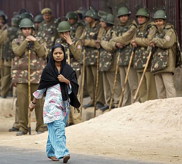A girl walks pasts policemen during a demonstration