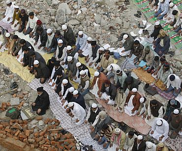 Muslims offer Friday prayers at the site of a demolished mosque