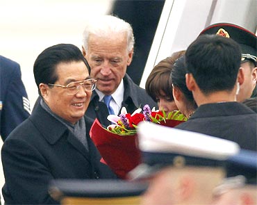 President Hu Jintao receives flowers upon his arrival at Andrews Air Force Base near Washington for a state visitUS Vice President Joe Biden is at rear