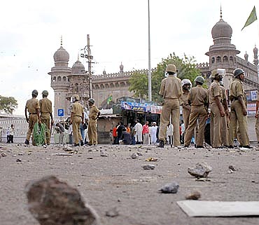 Policemen stand guard at the site of a blast in front of Mecca Masjid