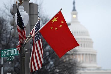 Chinese and American flags fly on a lamp post along Pennsylvania Avenue near the US Capitol
