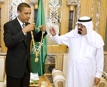 US President Barack Obama holds a gift he received from Saudi Arabia's King Abdullah during a meeting at the King's farm outside Riyadh