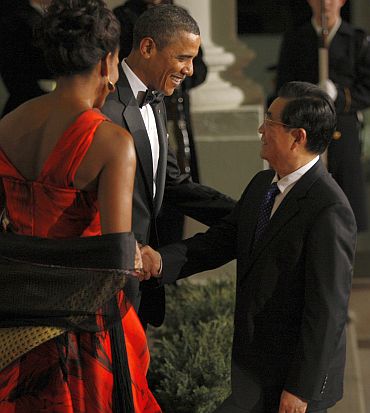 US President Barack Obama and first lady Michelle Obama greet China's President Hu Jintao as he arrives for a State Dinner in his honour at the White House