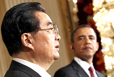 US President Barack Obama looks on as Chinese President Hu Jintao speaks during a joint news conference in Washington