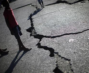 A child walks past a crack caused by the earthquake in a street in Port-au-Prince January 16, 2010