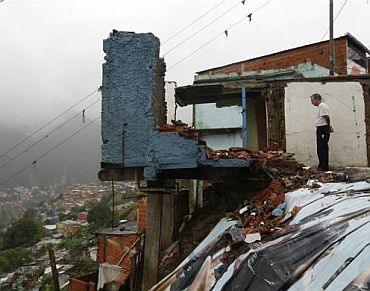 A man looks at a destroyed house in the low-income neighborhood of Catia in Caracas, Venezuela, December 1, 2010