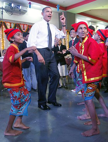 US President Barack Obama dances with children in a school in Mumbai
