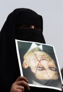 A veiled protester holds a photo of Egypt's President Hosni Mubarak marked with an X, during a demonstration