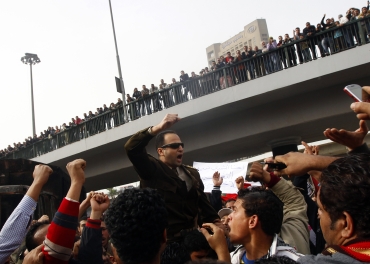 Egyptians carry an army officer who joined the protesters at Tahrir square in Cairo