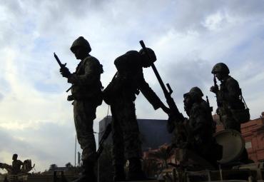 Egyptian army soldiers stand on top of an armoured vehicle in Cairo