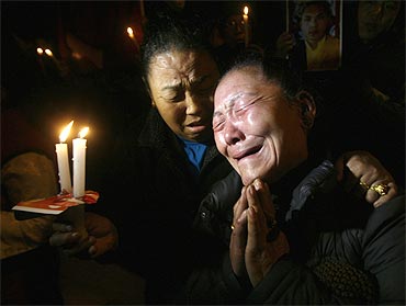 Tibetan exiles weep during a candlelight vigil in support of the Karmapa Lama in New Delhi