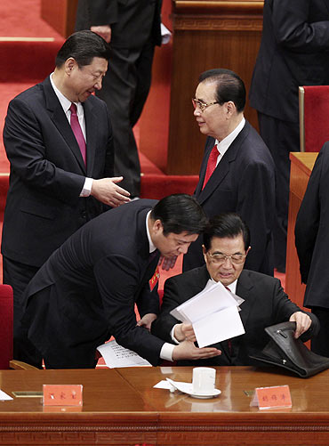 Hu Jintao (bottom R), China's president and general secretary of the Communist Party of China (CPC), gathers his papers as Vice President Xi Jingping (L) shakes hands with former Premier Li Peng after the celebration of the 90th anniversary.