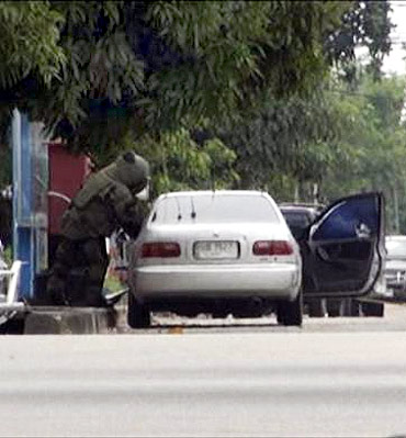 A member of a Thai bomb squad checks a car in Narathiwat province, south of Bangkok