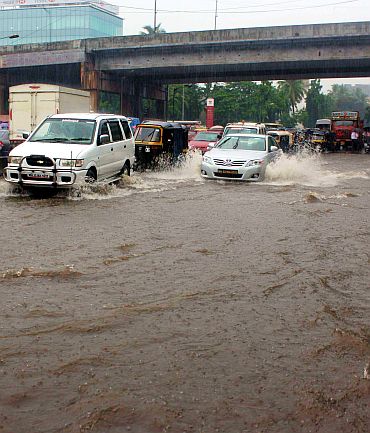 Vehicles cross a flooded intersection in Andheri