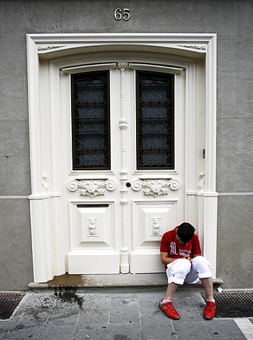 A reveller sleeps on the street after the first bull run