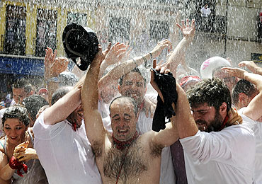 Revellers are showered with water during the start of the San Fermin Festival